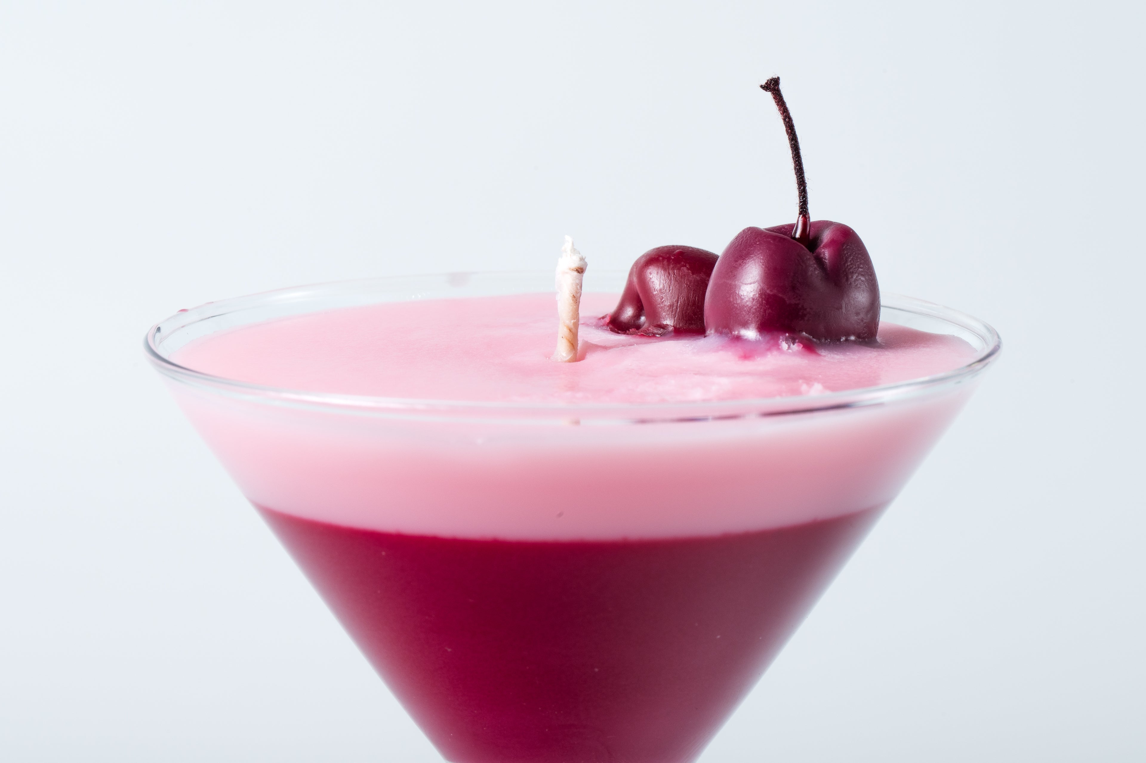 lumânare handmade în formă de cocktail, turnată în pahar martini și decorată cu cireșe din ceară
