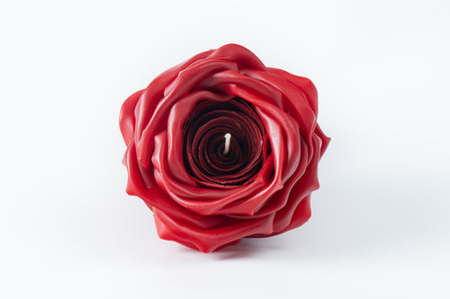 Red rose-shaped candle on a white background