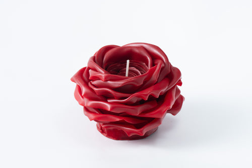 Red rose-shaped candle on a white background