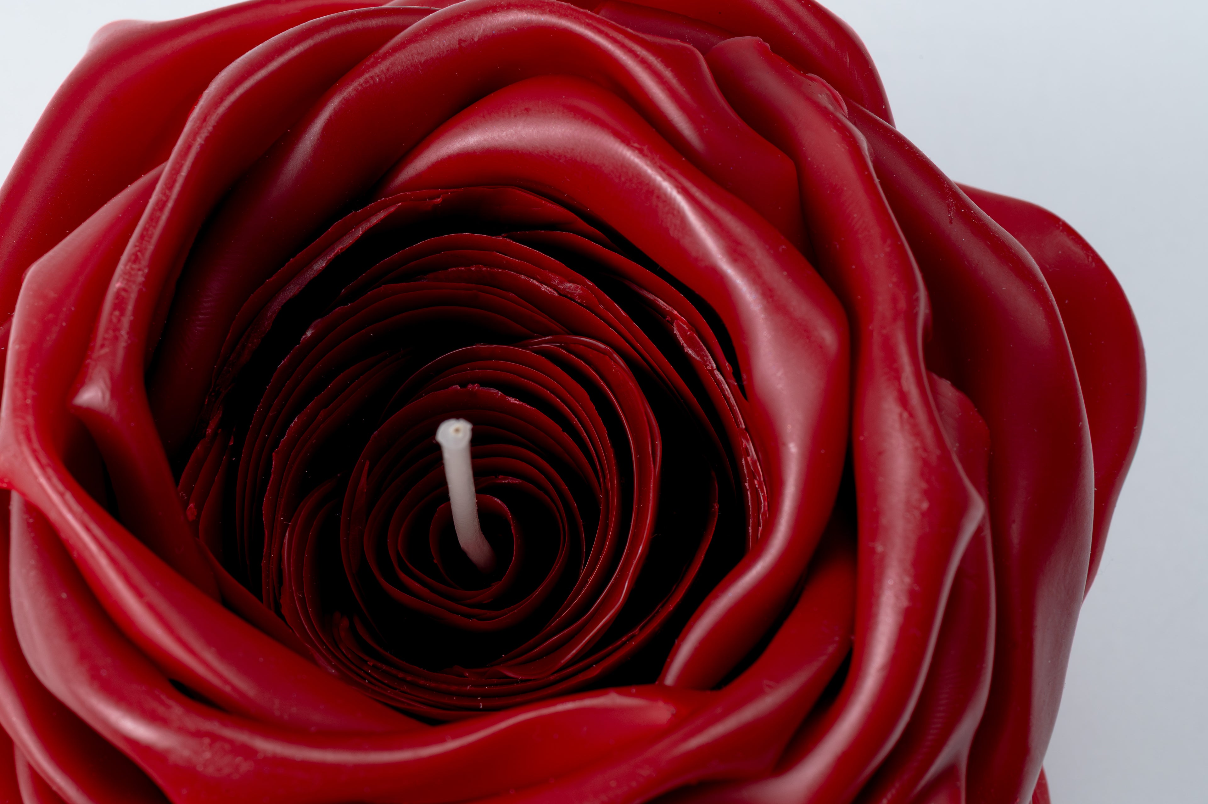 Red rose-shaped candle on a white background