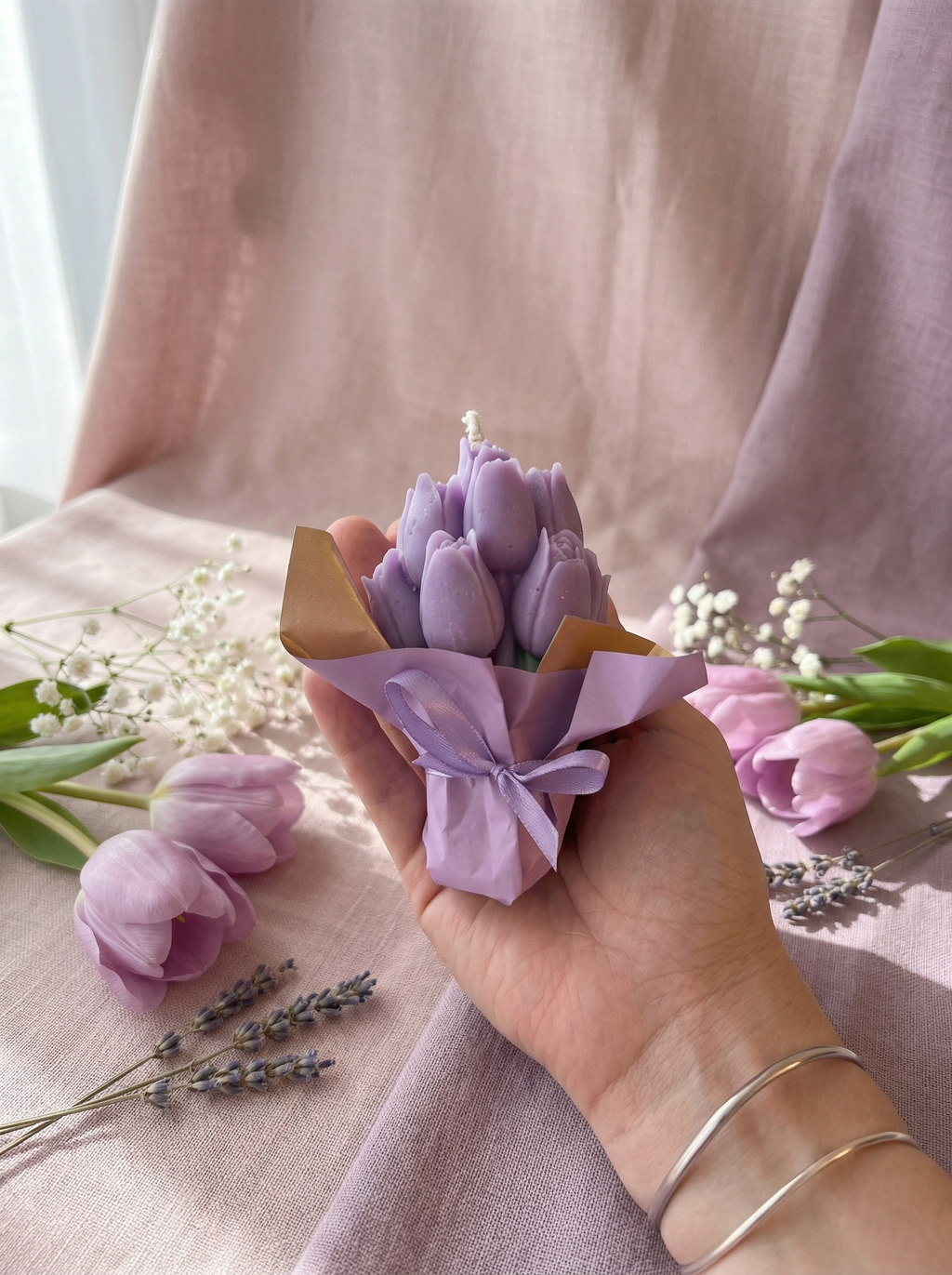 lumânare artizanala parfumata in forma de buchet de lalele mov, împachetat manual în hârtie pastel și legat cu fundă
